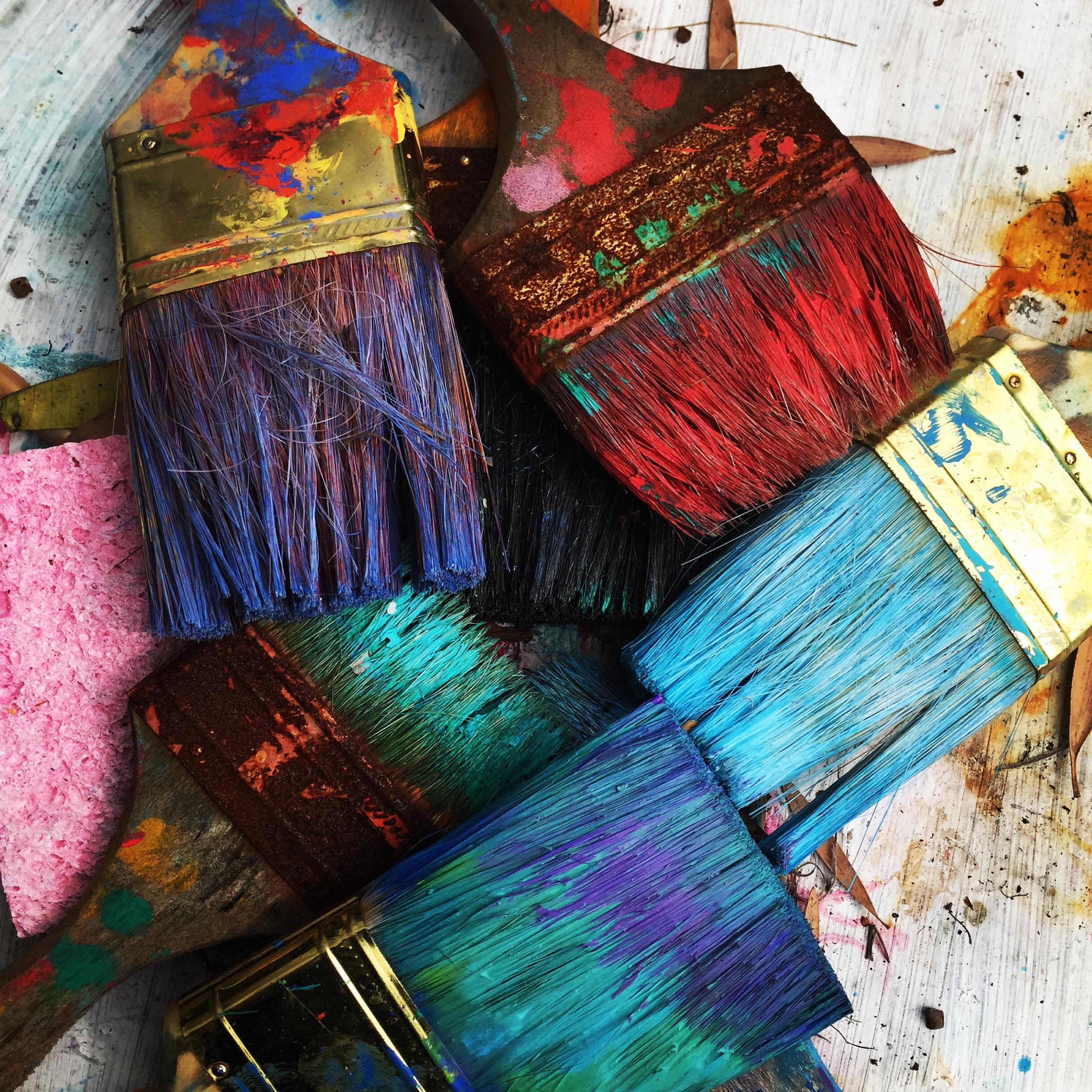 photo of paint brushes with different coloured paints, for blog post on colour psychology, paint your home happy